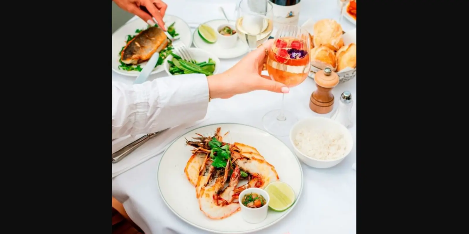 Plat de gambas et cocktail Miss Amourette sur une table en terrasse