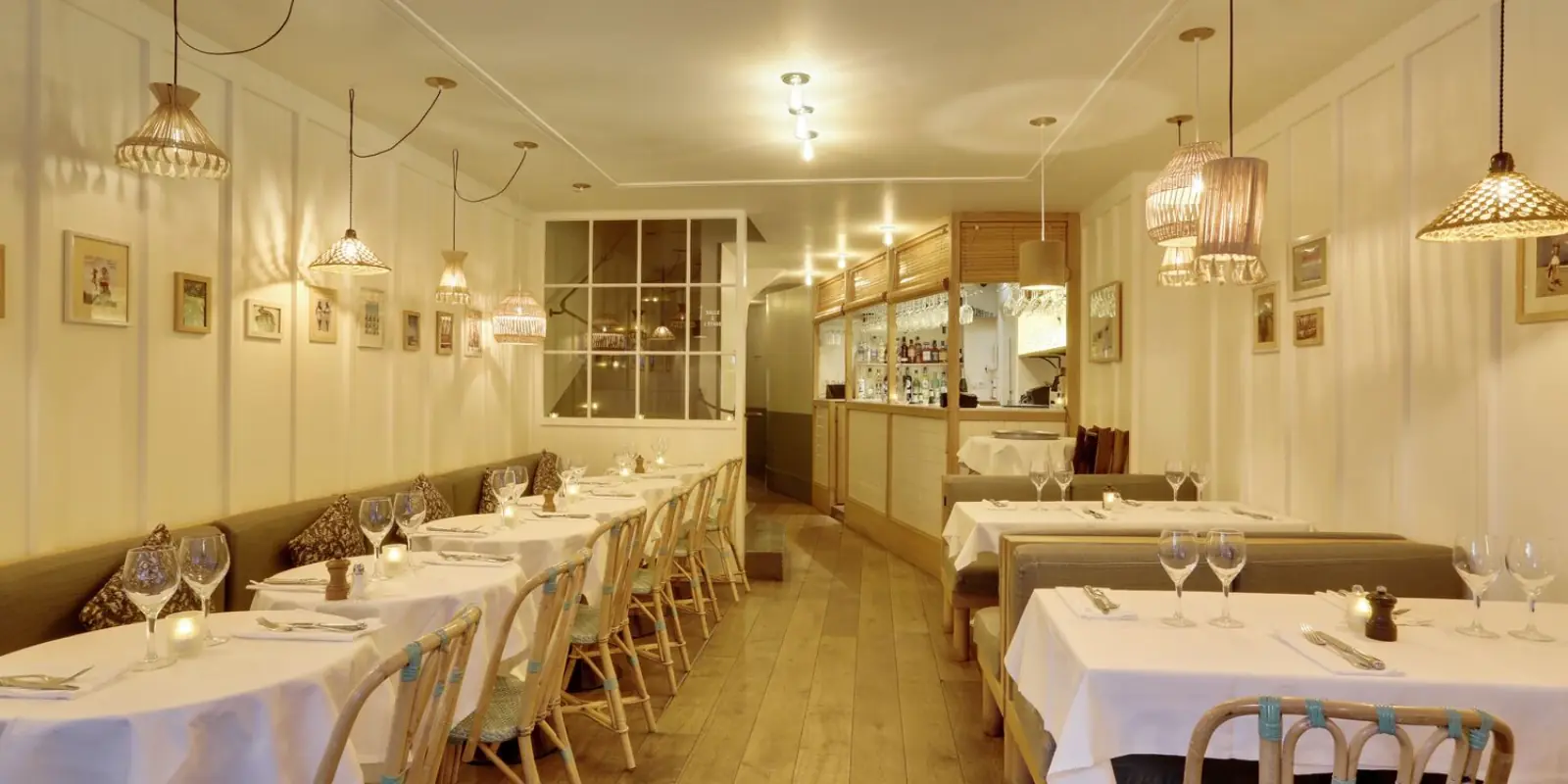 Interior of Amourette Passy with rattan pendant lights and dining tables
